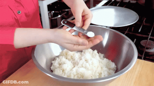 A Person Adding Salt To A Bowl Of Rice GIF