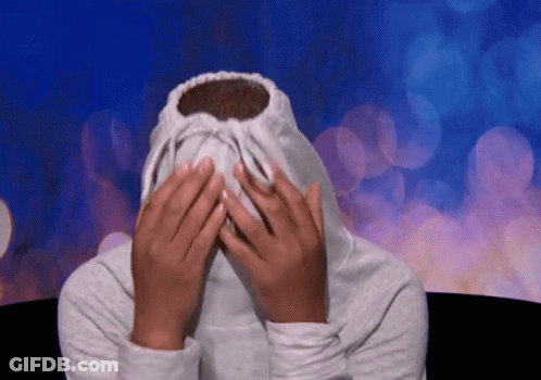 A Person Covering Their Face With A White Sweatshirt GIF