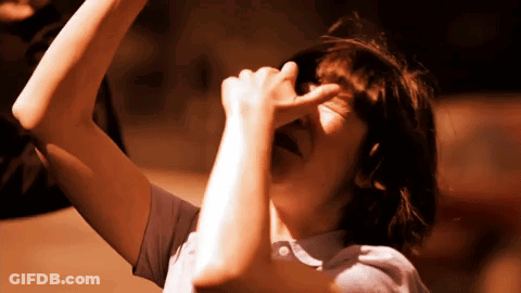 A Person Covering Their Face With Their Hand While Looking Up GIF