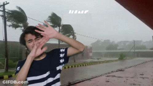 A Person Covering Their Face With Their Hands In Front Of A Sign That Says Hump GIF