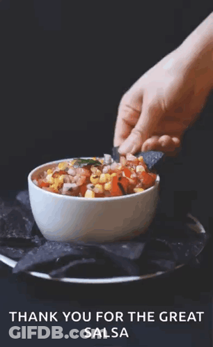 A Person Dipping A Chip Into A Bowl Of Salsa GIF