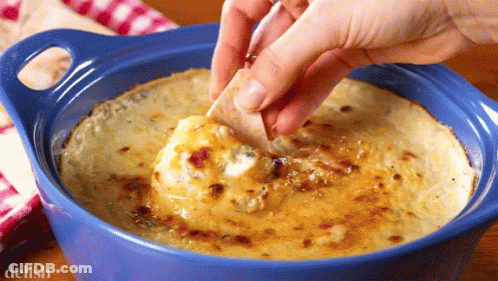A Person Dipping A Tortilla Chip Into A Bowl Of Dip With The Word Delish On The Bottom GIF
