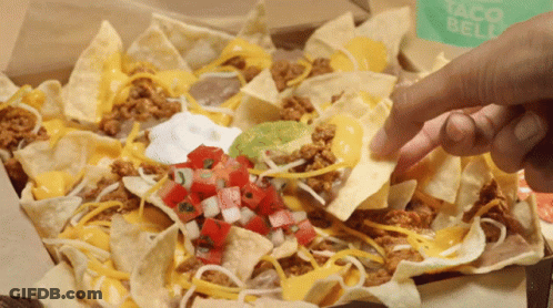 A Person Dipping A Tortilla Chip Into A Box Of Nachos GIF