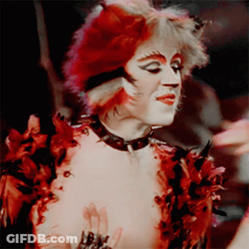 A Person Dressed As A Cat With Red Hair GIF