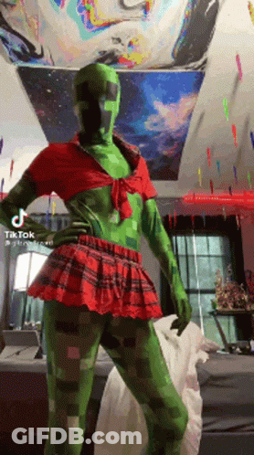 A Person Dressed As A Creeper In A Red And Green Outfit GIF