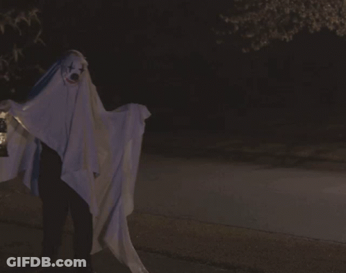 A Person Dressed As A Ghost Holding A Lantern With The Word Boo Written On The Bottom GIF
