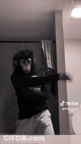 A Person Dressed As A Monkey Is Dancing In Front Of A Mirror GIF