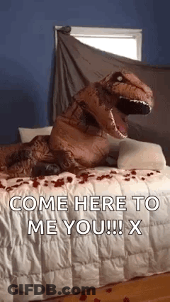 A Person Dressed As A T-Rex Is Sitting On A Bed With Roses On It . GIF