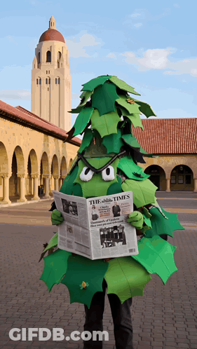 A Person Dressed As A Tree Is Reading A Newspaper Called The Times GIF
