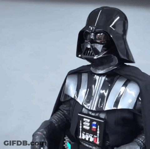 A Person Dressed As Darth Vader From Star Wars Holds A Remote Control GIF