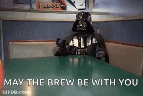 A Person Dressed As Darth Vader Is Sitting At A Table In A Diner And Saying `` May The Brew Be With You '' GIF