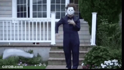 A Person Dressed As Michael Myers Is Walking Down A Set Of Stairs . GIF