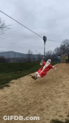 A Person Dressed As Santa Claus Is Riding A Zip Line GIF