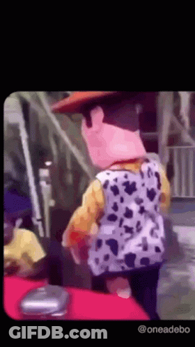 A Person Dressed As Woody From Toy Story Is Standing On A Red Carpet . GIF