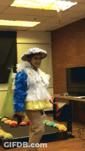 A Person Dressed In A Colorful Costume With A Hat On GIF