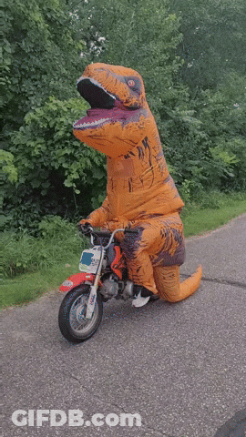 A Person Dressed In A T-Rex Costume Is Riding A Small Motorcycle GIF