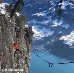 A Person Hanging From A Rope On A Cliff With The Words " Awesome " Above Them GIF