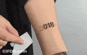 A Person Has A Tattoo On Their Arm That Says ' 2018 ' GIF