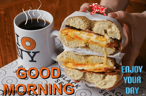 A Person Holding A Bagel Next To A Mug That Says I Love New York GIF