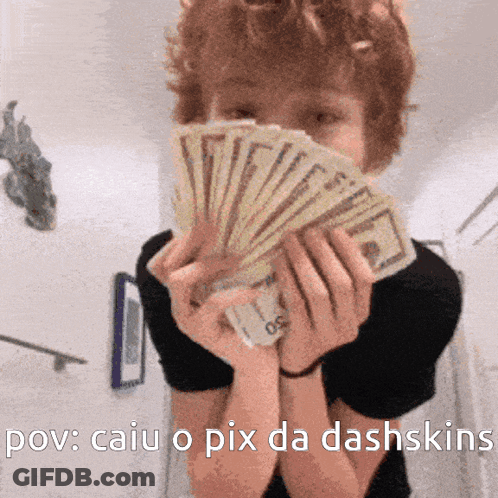 A Person Holding A Bunch Of Money In Front Of Their Face GIF