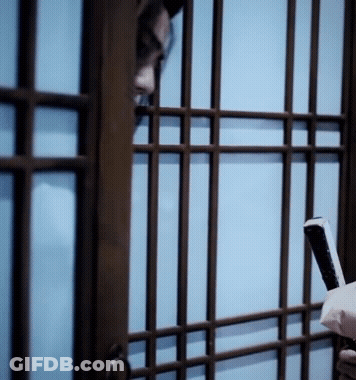 A Person Holding A Cell Phone Behind Bars GIF