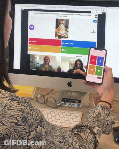 A Person Holding A Cell Phone In Front Of A Computer Screen That Says 16 GIF