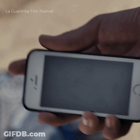 A Person Holding A Cell Phone With La Guarimba Film Festival Written In The Background GIF
