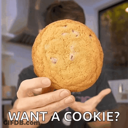 A Person Holding A Cookie With The Words Want A Cookie Written Below It GIF
