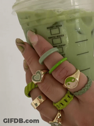 A Person Holding A Cup Of Green Liquid That Says Decaf / Deca GIF