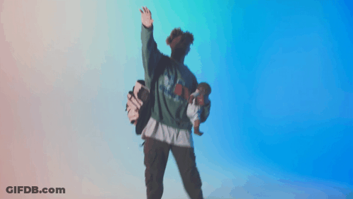 A Person Holding A Doll And A Golf Bag While Wearing A Green Shirt That Says ' Texas ' On It GIF