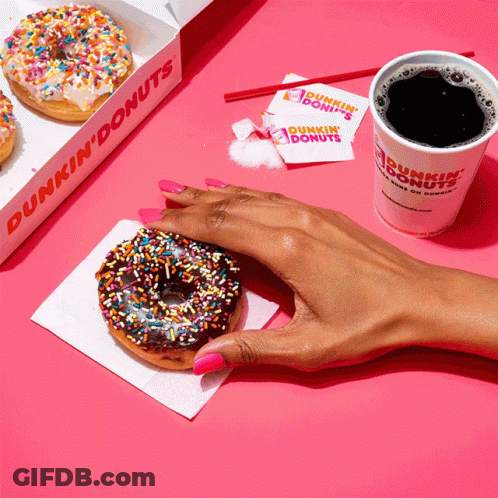 A Person Holding A Donut Next To A Dunkin Donuts Cup GIF