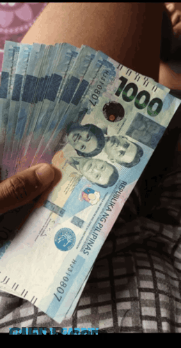 A Person Holding A Fan Of 1000 Peso Bills GIF
