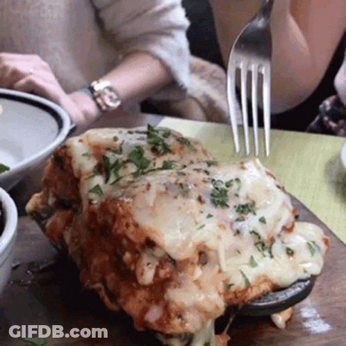 A Person Holding A Fork Over A Piece Of Food GIF
