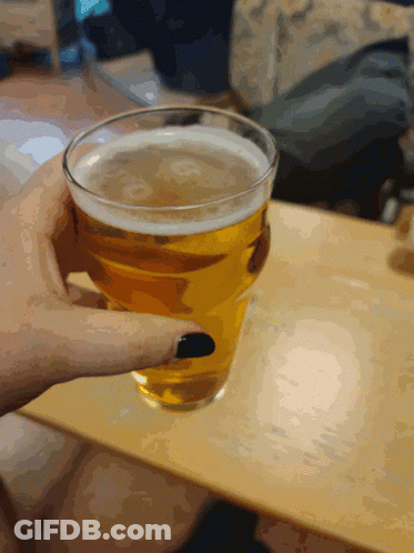 A Person Holding A Glass Of Beer With Black Nails GIF