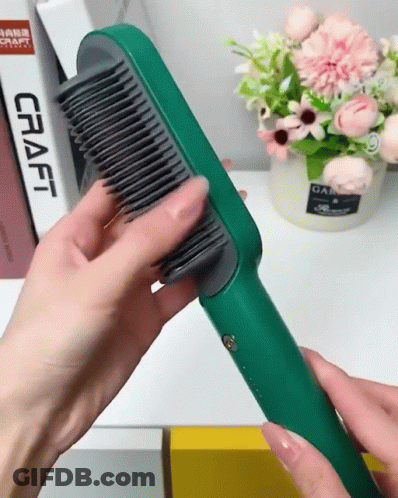 A Person Holding A Green Comb In Front Of A Craft Book GIF