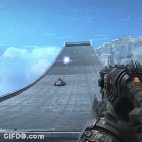 A Person Holding A Gun In Front Of A Ramp With A Car Going Down It GIF