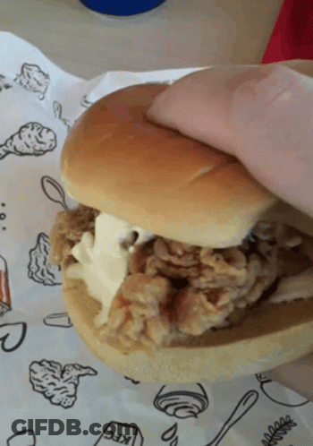 A Person Holding A Kfc Chicken Sandwich On A Bun GIF