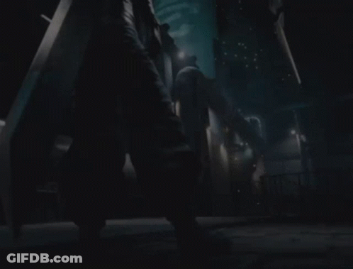 A Person Holding A Large Sword Standing In A Dark Room GIF