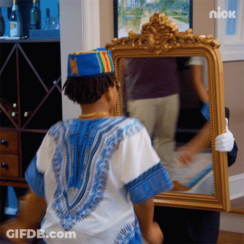 A Person Holding A Mirror With A Nick Logo On The Bottom Left GIF