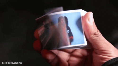 A Person Holding A Piece Of Paper With A Picture Of A Woman On It GIF