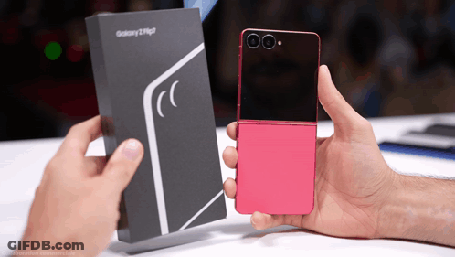A Person Holding A Pink Flip Phone Next To A Box That Says Galaxy GIF