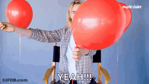 A Person Holding A Red Balloon With The Word Yeah Written On It GIF