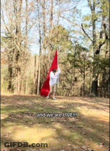A Person Holding A Red Flag With The Words And We Are Live Written On The Bottom GIF