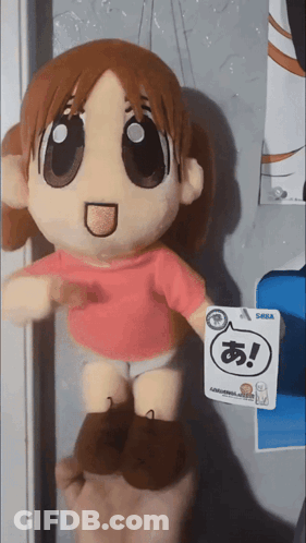 A Person Holding A Stuffed Doll With A Tag That Says Sega GIF