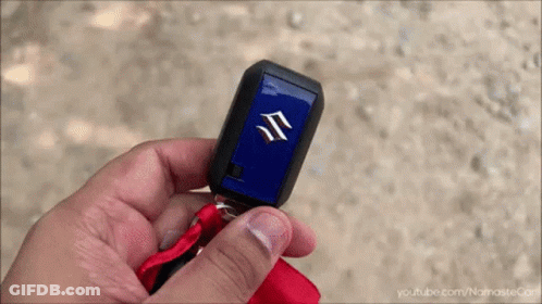 A Person Holding A Suzuki Car Key In Their Hand GIF