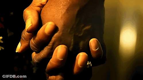 A Person Holding Another Person 'S Hand In A Dark Room GIF