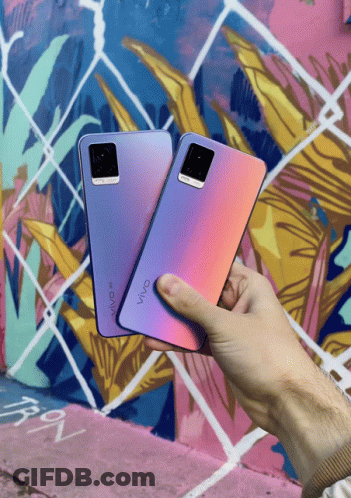 A Person Holding Two Vivo Phones In Front Of A Colorful Mural GIF