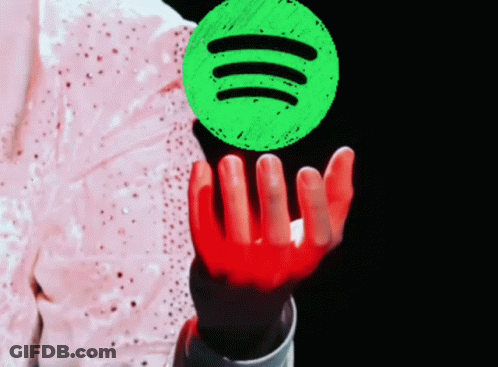 A Person Holding Up A Green Spotify Logo GIF