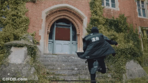 A Person In A Black Jacket With Chinese Writing On The Back Is Running Down Stairs GIF