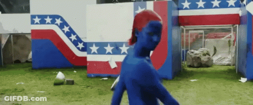 A Person In A Blue Costume Is Walking In Front Of A Red White And Blue Building With Stars On It . GIF